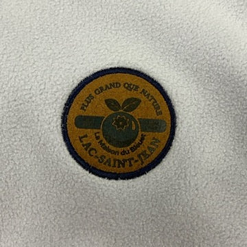 Ecusson se trouvant à l'avant du Polar Retro Beige et Bleu Marine