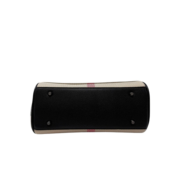 Bottom view of a La Maison du Bleuet structured vegan leather handbag with protective metal feet in black.
