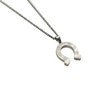 La Maison du Bleuet matte silver stainless steel horseshoe pendant necklace with a durable chain on marble surface