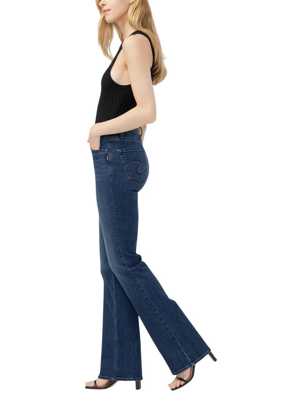 Maison Taïga Avery curvy high-waisted dark indigo bootcut jeans in power stretch denim worn by a model, side view.