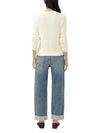 Back view of a model wearing Maison Taïga mid-rise relaxed straight-leg jeans in indigo denim with cuffed hems.