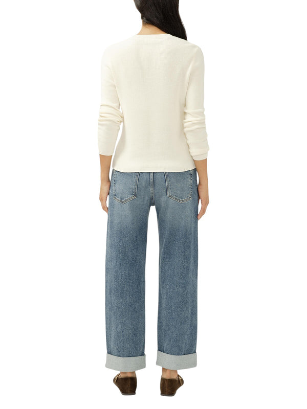 Back view of a model wearing Maison Taïga mid-rise relaxed straight-leg jeans in indigo denim with cuffed hems.