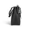 Sac à main Maison Taïga Évasion noir en PVC avec texture grainée et détail de foulard imprimé, vue de profil.