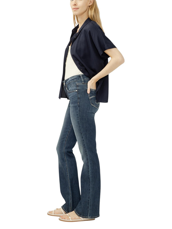 Model wearing Maison Taïga Silver Jeans Co. Suki mid-rise bootcut jeans in dark indigo Sundown wash from the side