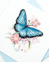 Carte de vœux papillon bleu et fleurs roses en papier roulé